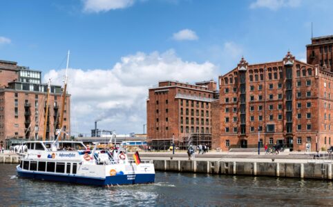 a boat traveling down a river next to tall buildings