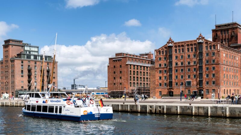 a boat traveling down a river next to tall buildings